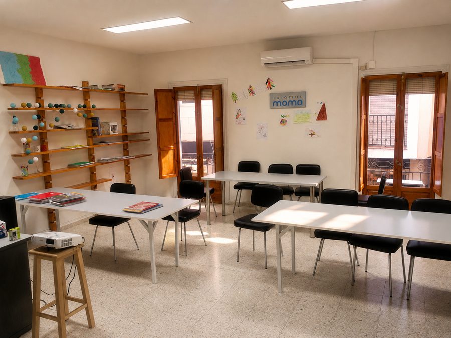 Aula de Idiomas Momo con mesas de trabajo, estantería y proyector