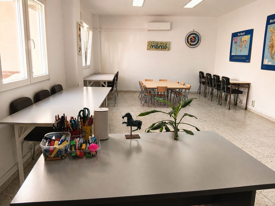 Otra aula de Idiomas Momo con mesas en U, mapas del mundo y material de clase