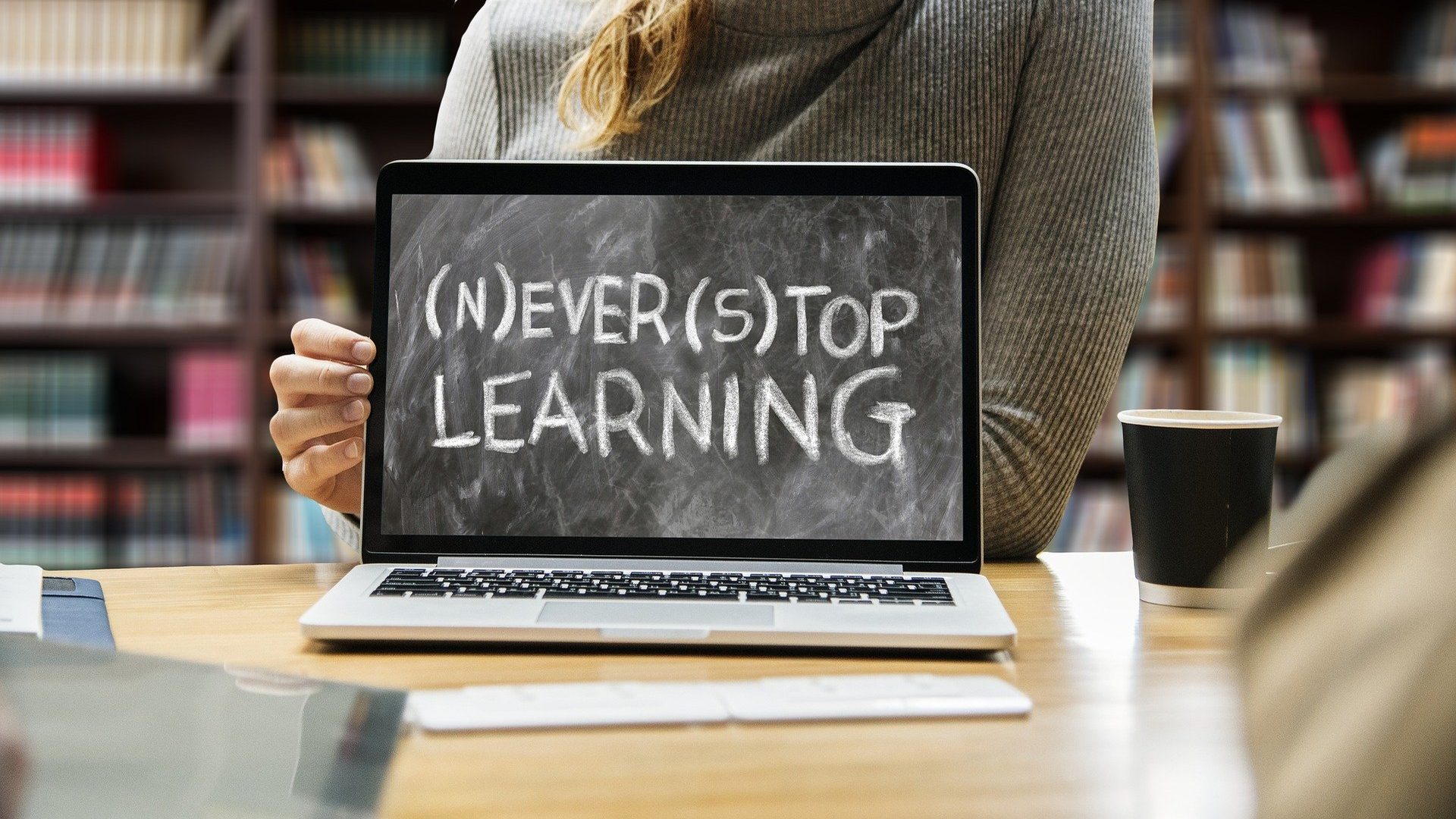 Alumna frente a un portátil con el lema Never stop learning